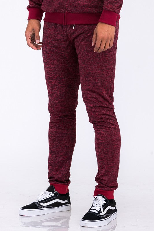 Maroon tracksuit with black and white sneakers on a white background