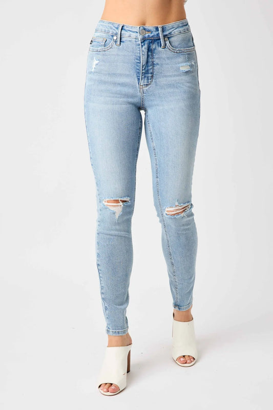 Light blue distressed jeans worn by a person on a white background