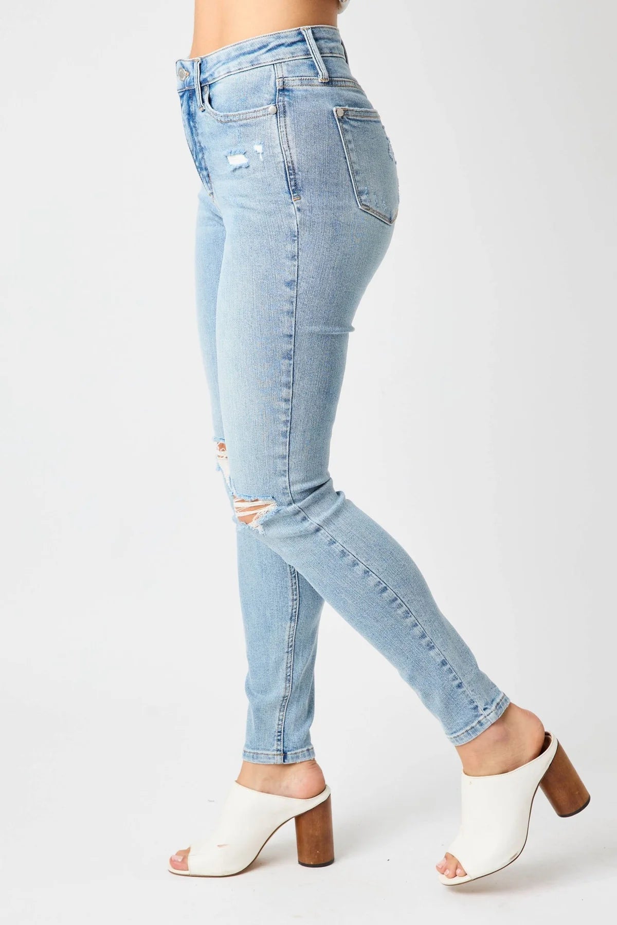 Light blue jeans worn by a person on a white background
