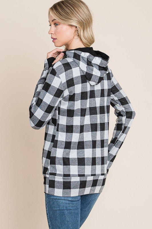 Woman wearing a black and white checkered jacket on a beige background
