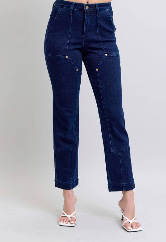 Dark blue jeans worn by a person on a light gray background