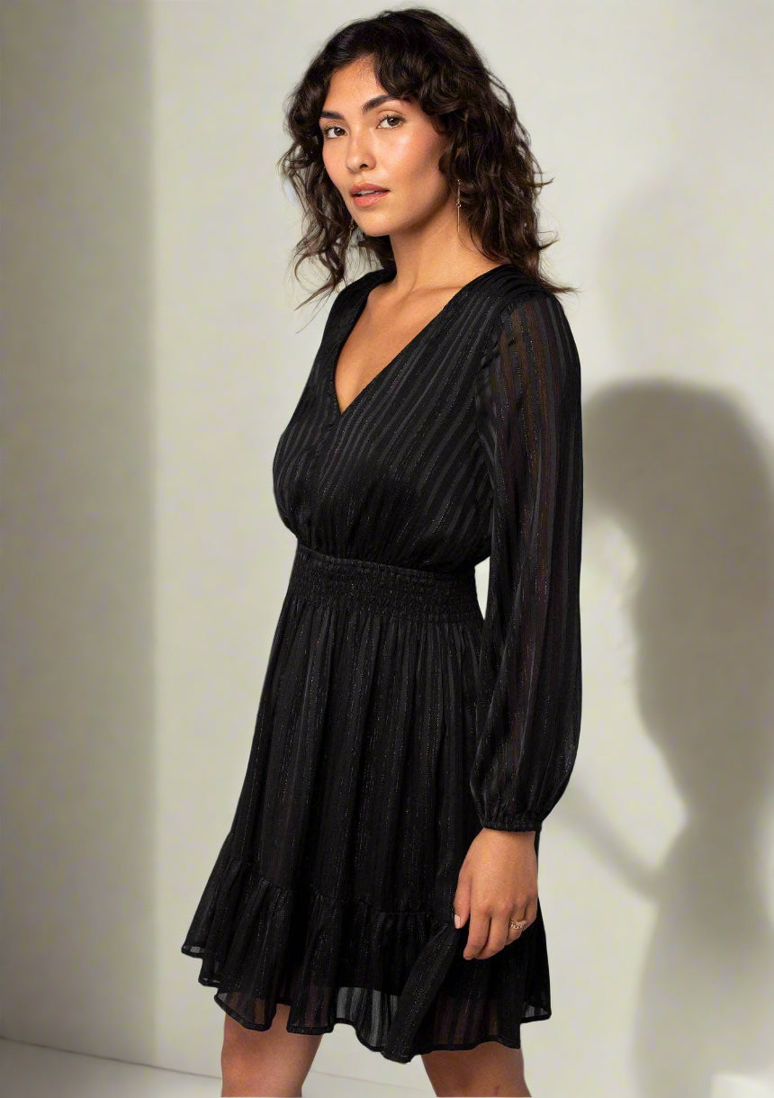 Woman wearing a black dress against a gray background