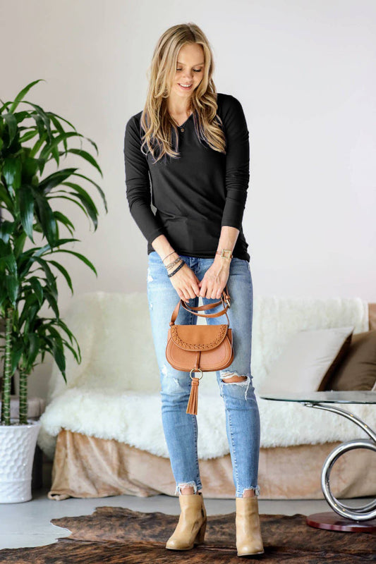 Woman holding a brown handbag in a living room setting
