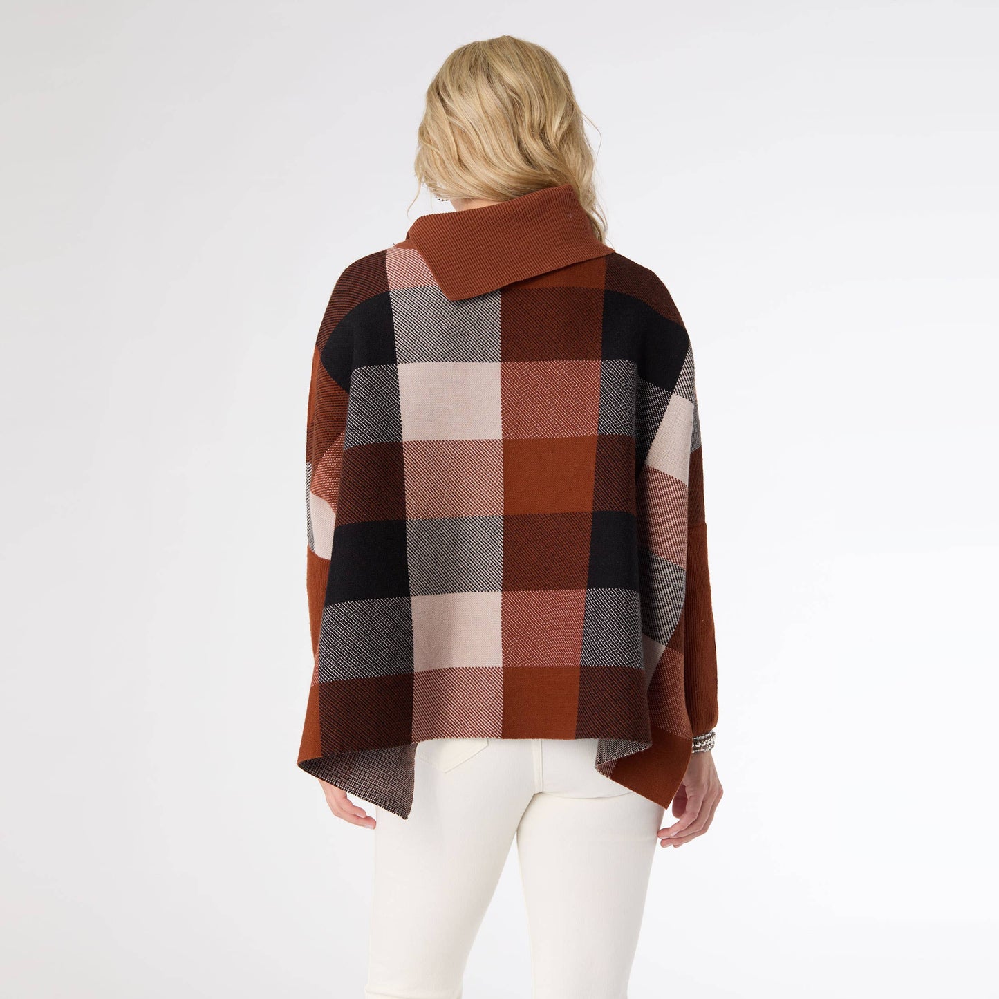 Person wearing a plaid poncho with a white background