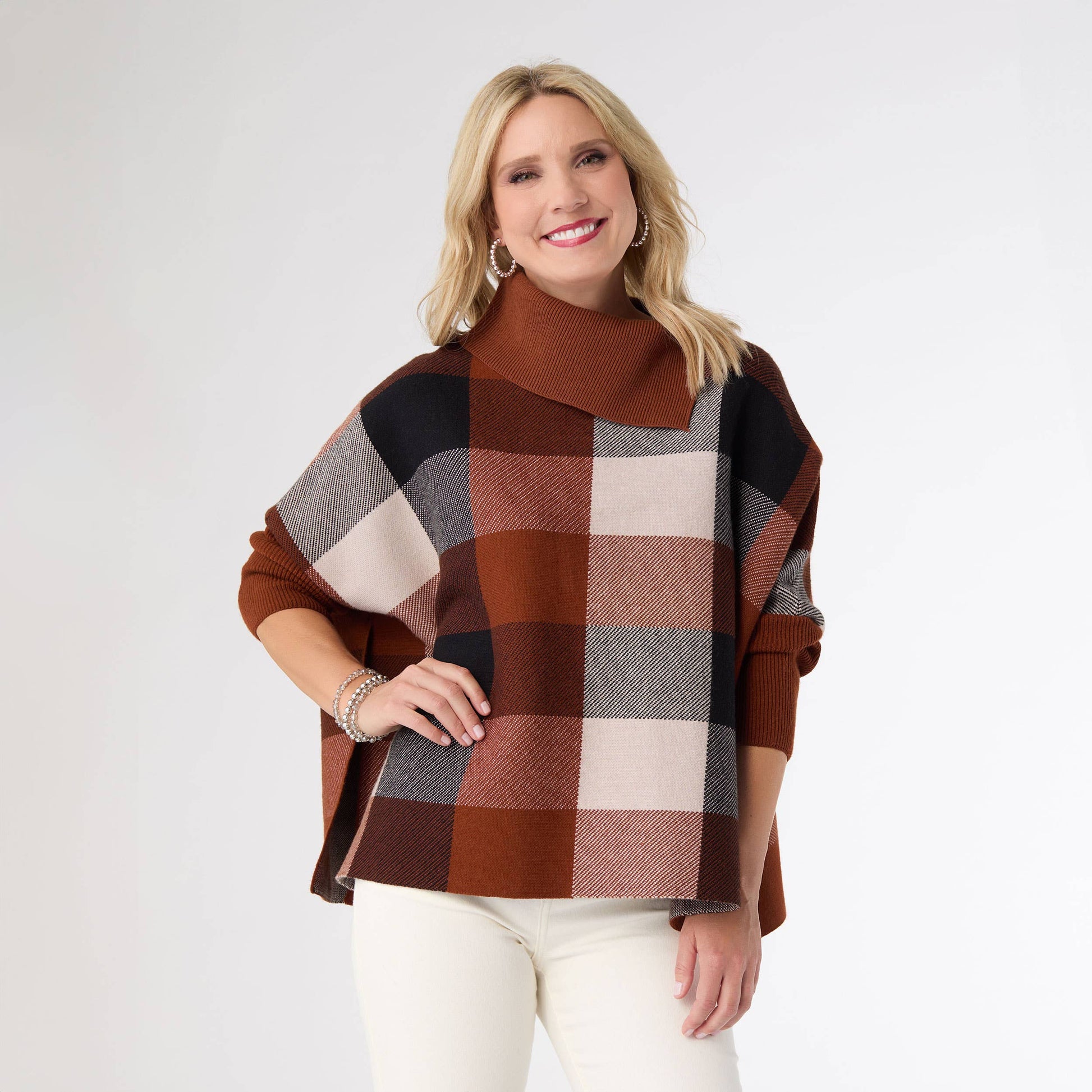 Woman wearing a plaid poncho on a white background