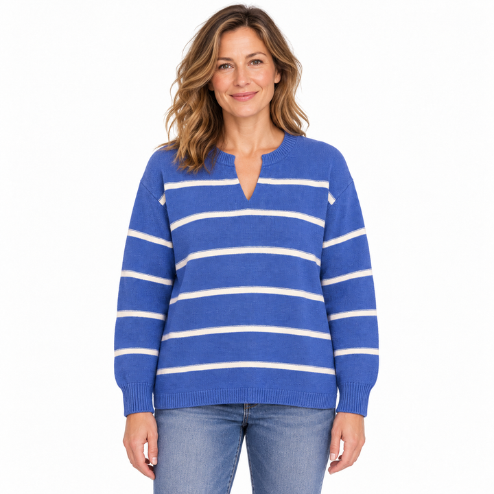 A woman wearing a blue and white horizontally striped knit sweater with a split V-neck, paired with blue jeans, photographed against a plain white background.