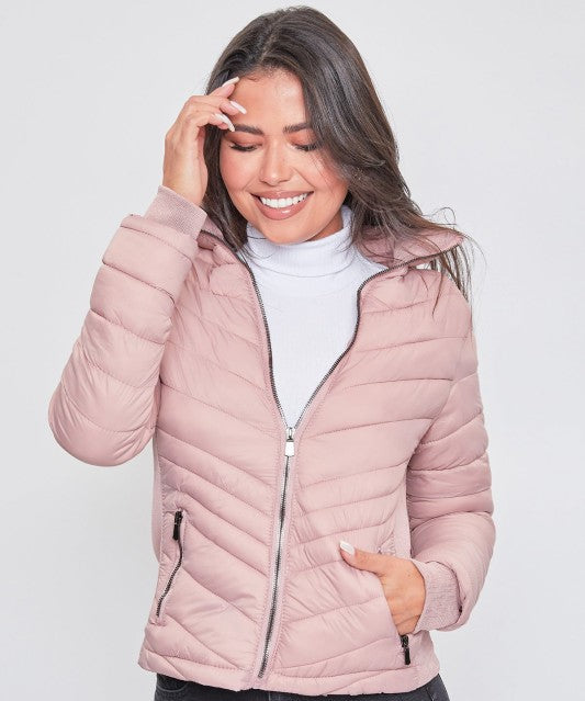 Woman wearing a pink quilted jacket on a white background