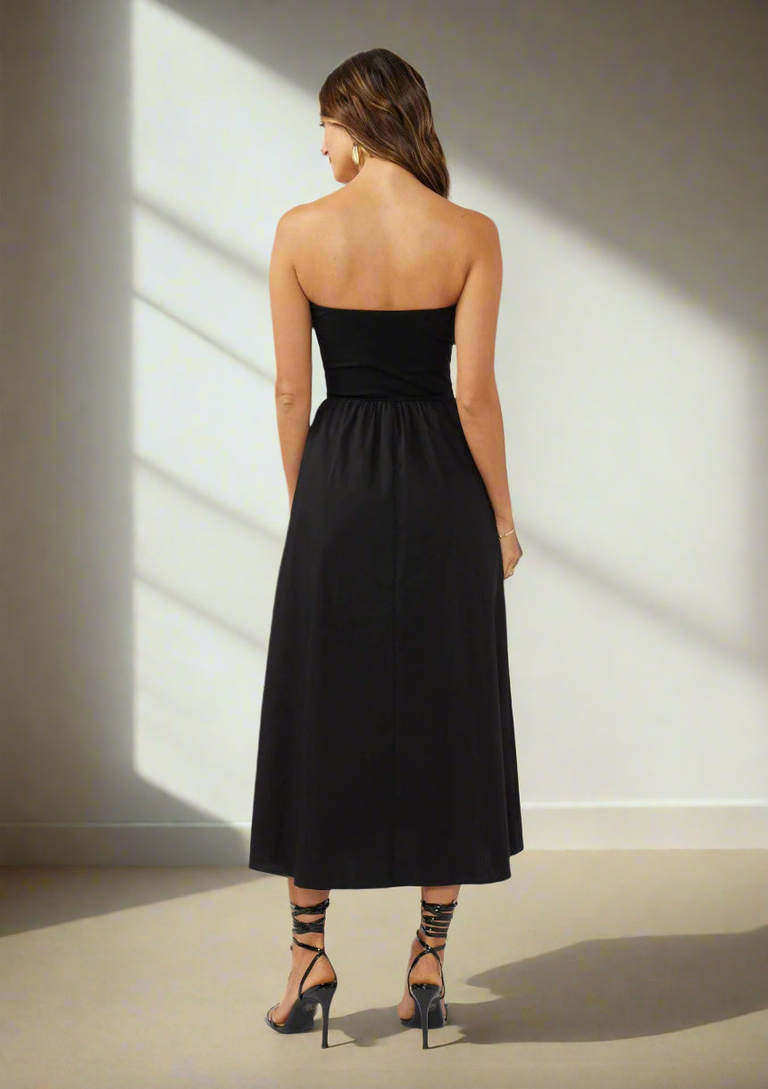 Woman wearing a black strapless dress on a white background