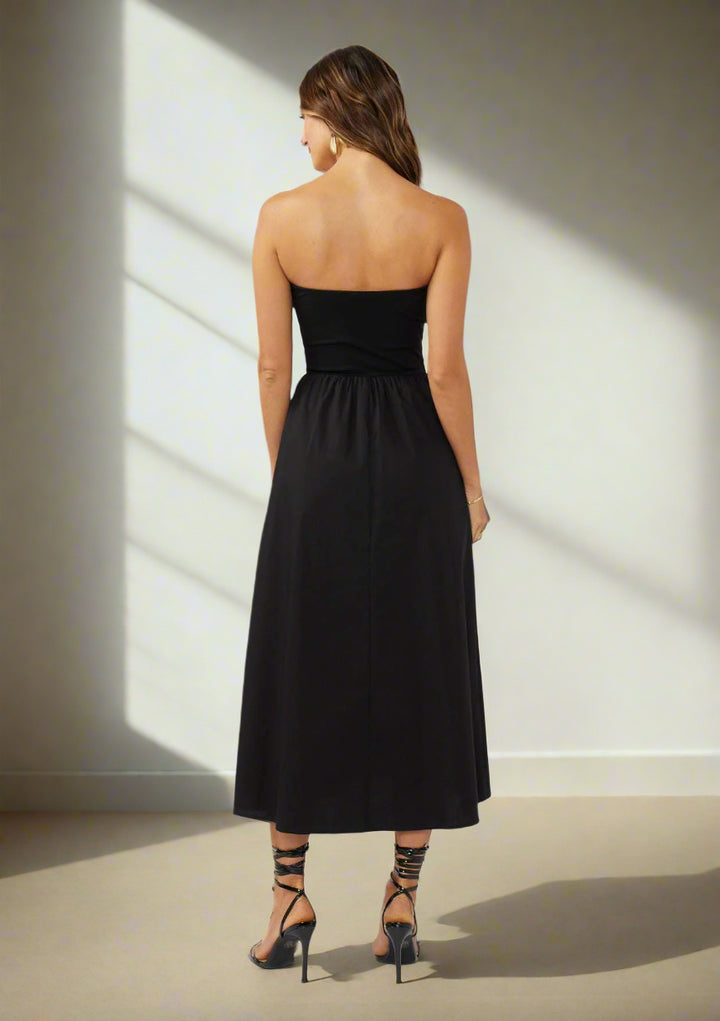 Woman wearing a black strapless dress on a white background