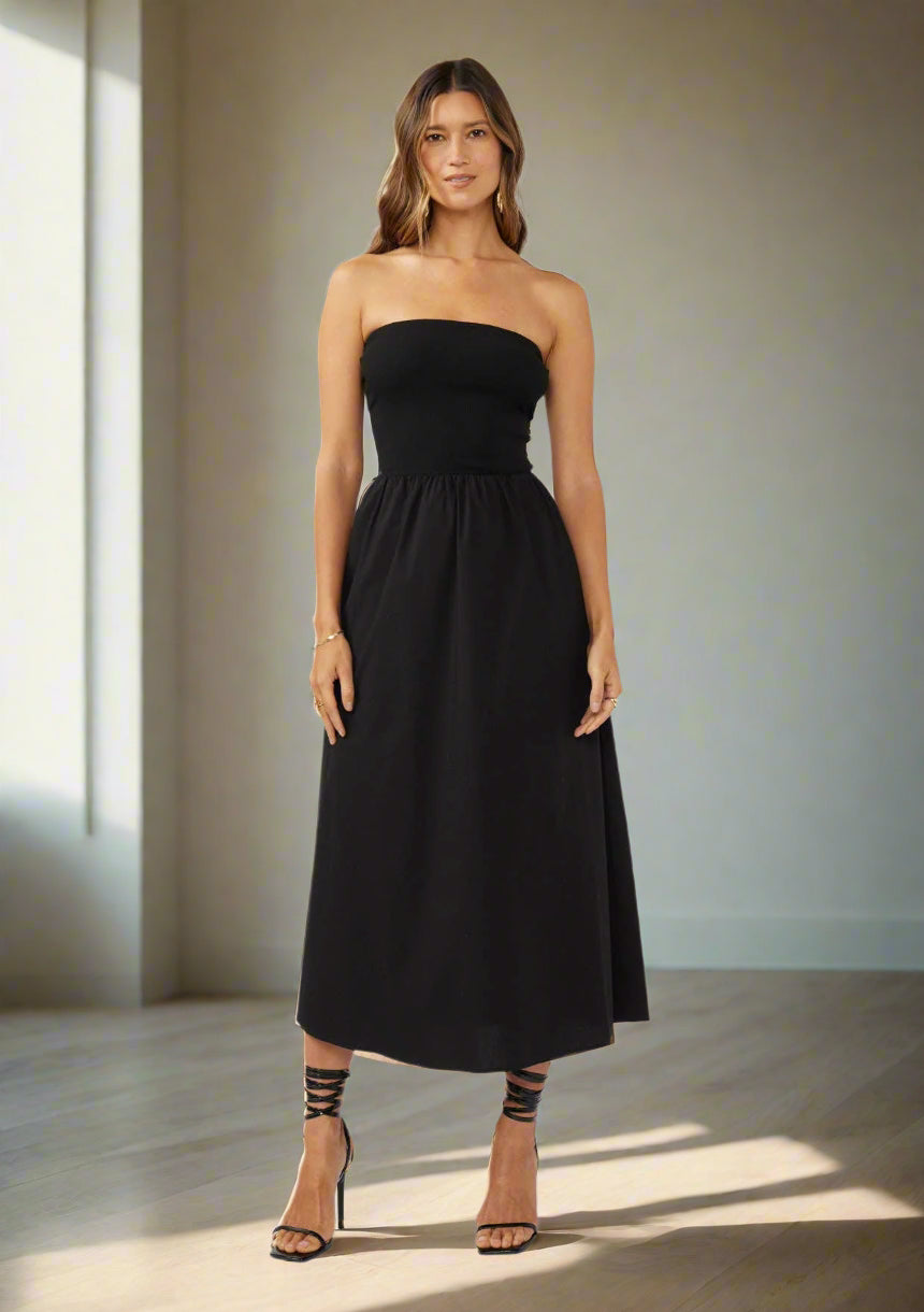 Woman wearing a black strapless dress on a white background