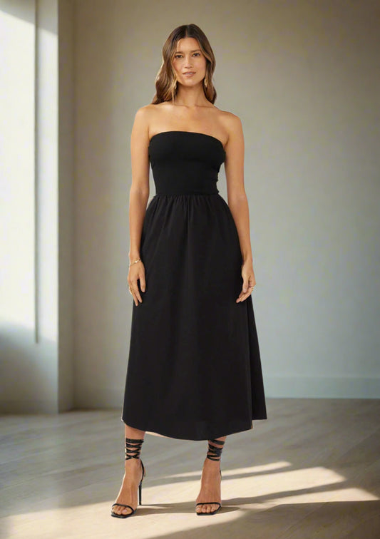 Woman wearing a black strapless dress on a white background