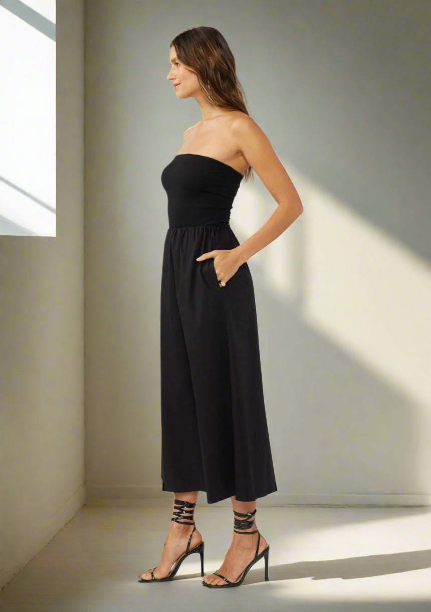 Woman wearing a black strapless dress on a white background