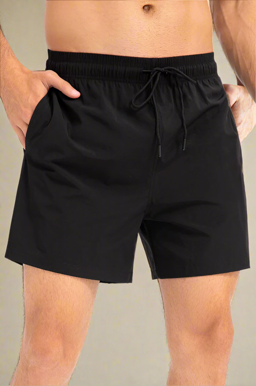 Black shorts worn by a person on a neutral background