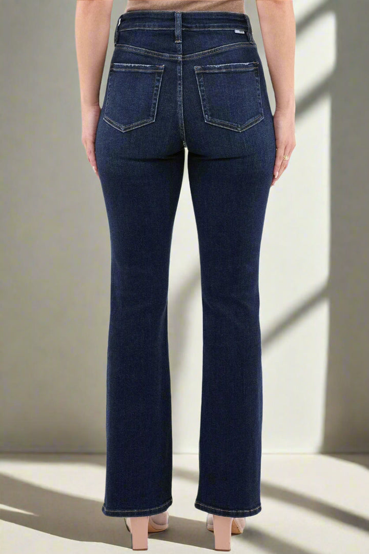 Dark blue jeans worn by a person on a white background
