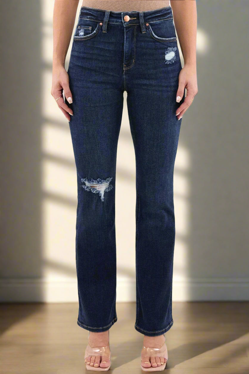 Dark blue jeans with slight distressing on a white background