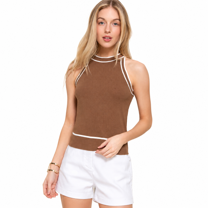 Woman wearing a brown sleeveless top with white trim and white shorts on a white background