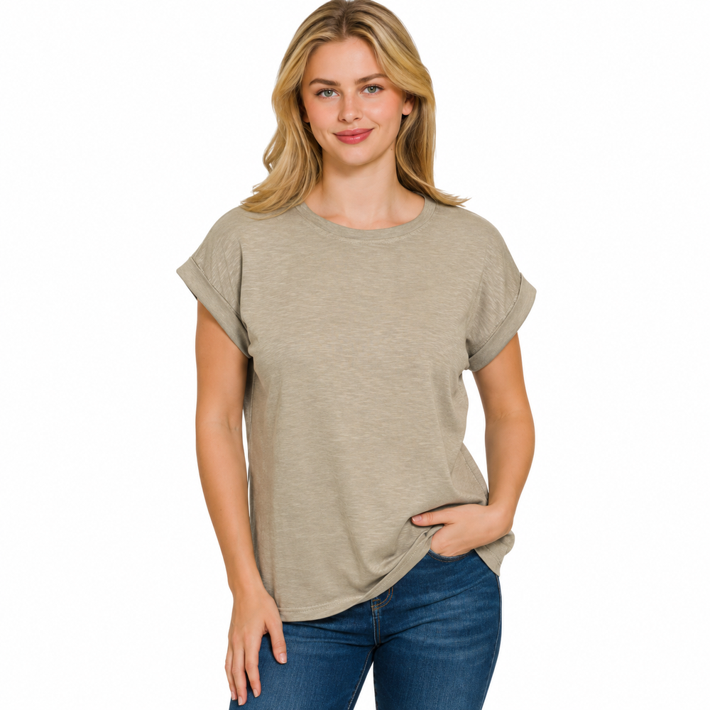 A woman modeling a short-sleeve crewneck t-shirt in a heathered light taupe-beige color, paired with blue jeans, against a solid white background.