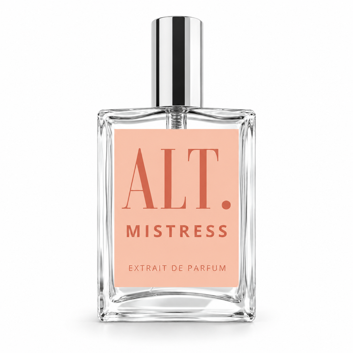 A clear glass perfume bottle with a rectangular shape, featuring a light peach-pink label with the text &