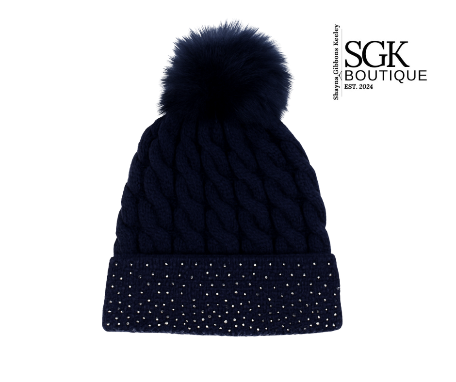Navy blue knit beanie with pom-pom on a white background, featuring SGK Boutique logo.