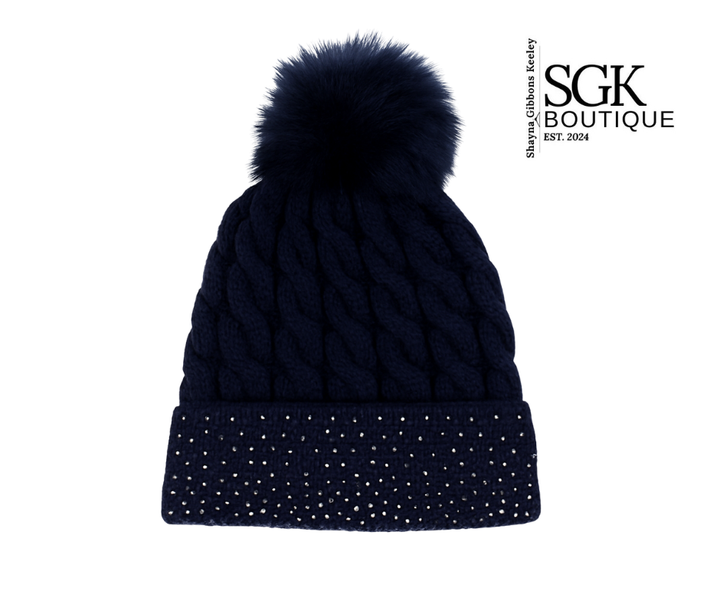 Navy blue knit beanie with pom-pom on a white background, featuring SGK Boutique logo.