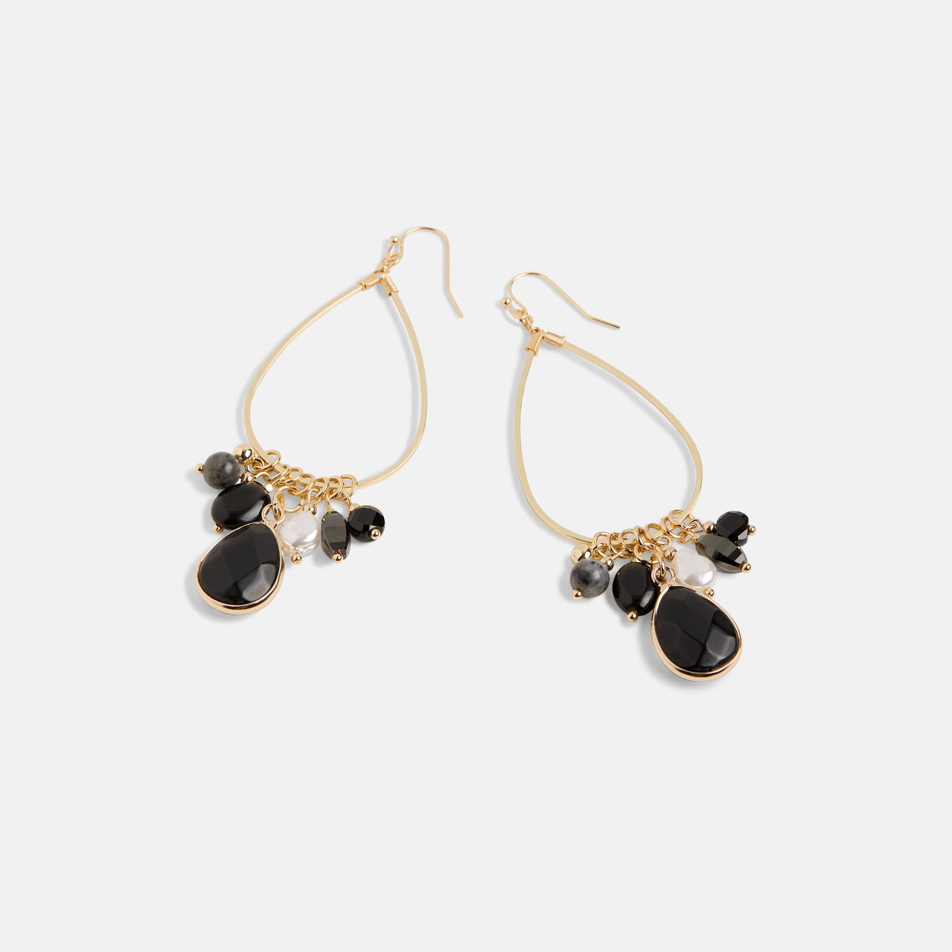 Gold earrings with black stones on a white background