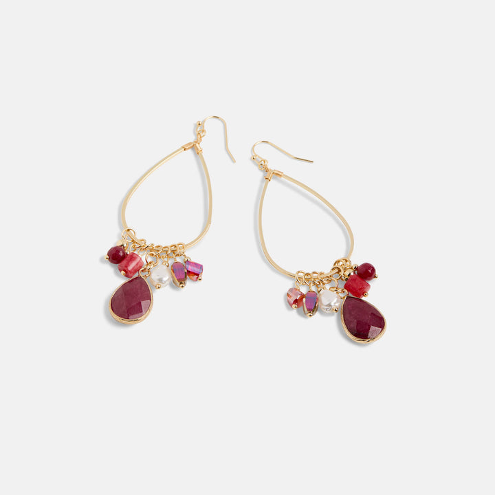 Gold earrings with red teardrop-shaped stones on a white background