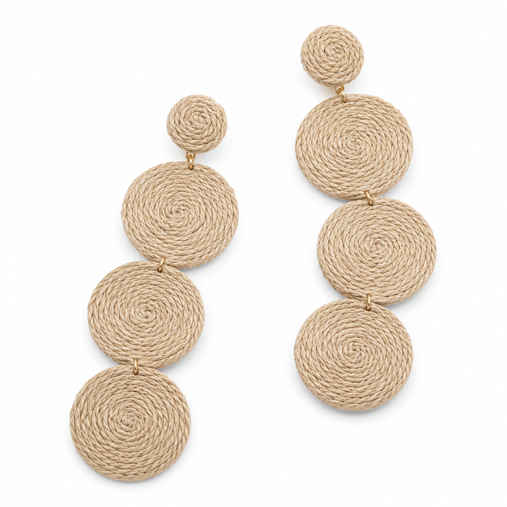 A pair of drop earrings made from natural beige woven jute rope, featuring a small spiral disc connected to larger stacked spiral discs, shown on a plain white background.