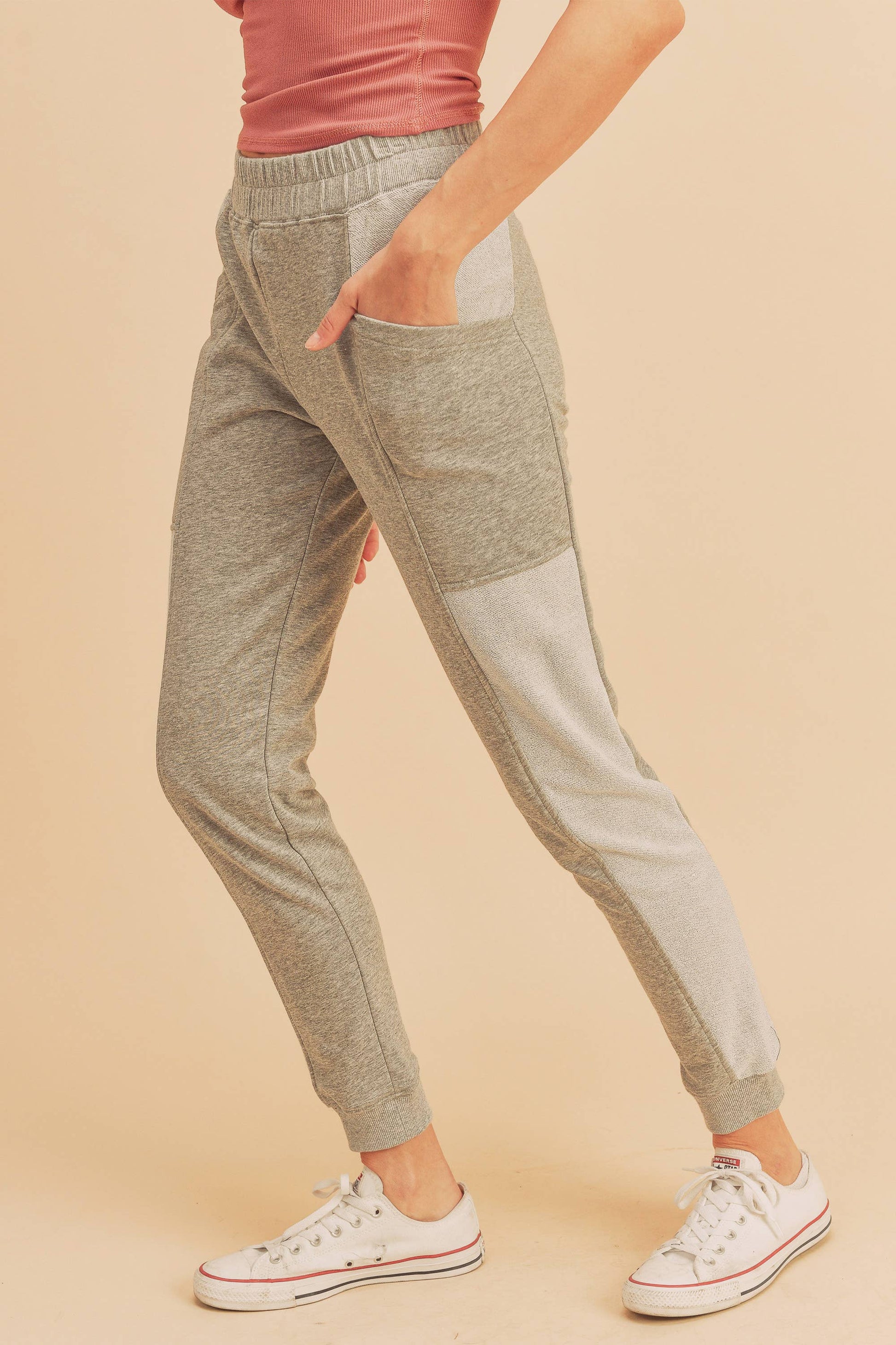 Gray jogger pants worn by a person on a beige background
