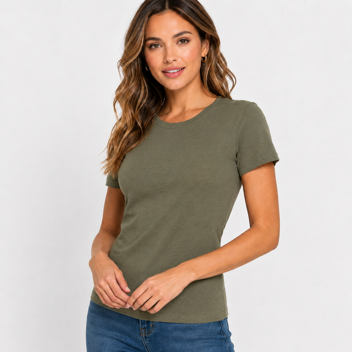 A woman modeling a short-sleeve crewneck t-shirt in olive green, paired with blue jeans, against a plain light gray studio background.
