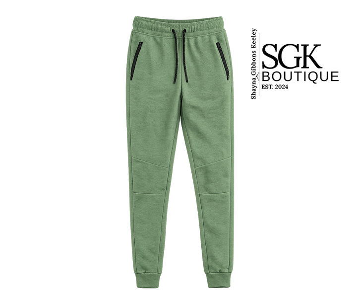 Green jogger pants with black zippers on a white background, featuring the SGK Boutique logo.