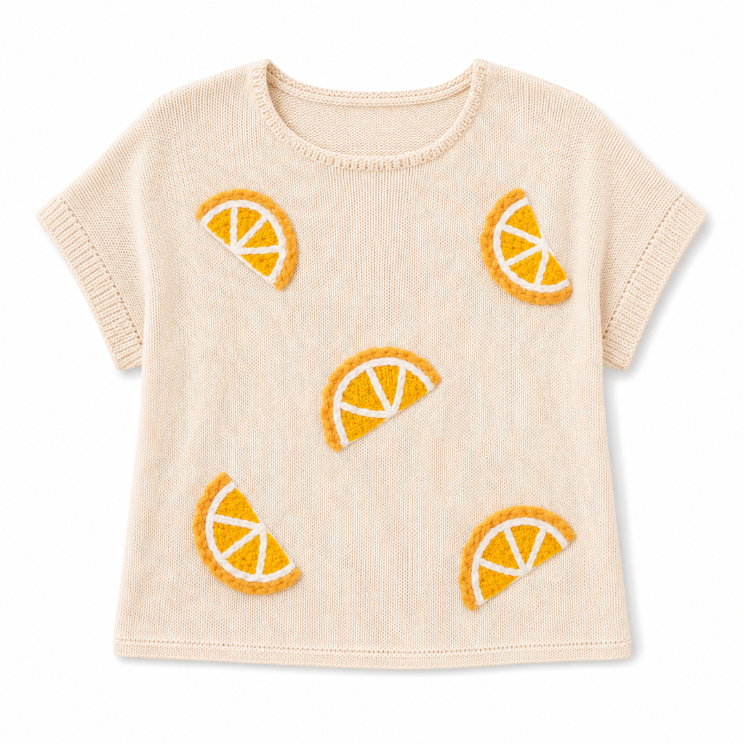 Beige knit sweater with orange slice patterns on a white background