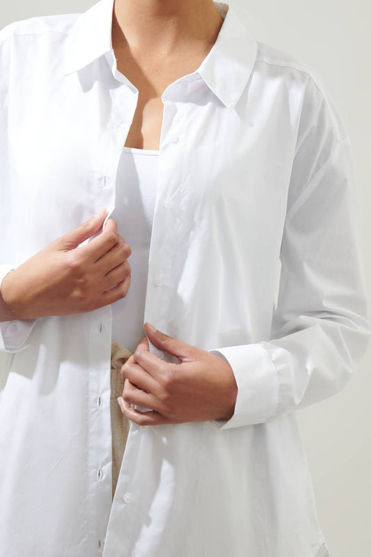 Close-up of a person wearing a white shirt with a plain background