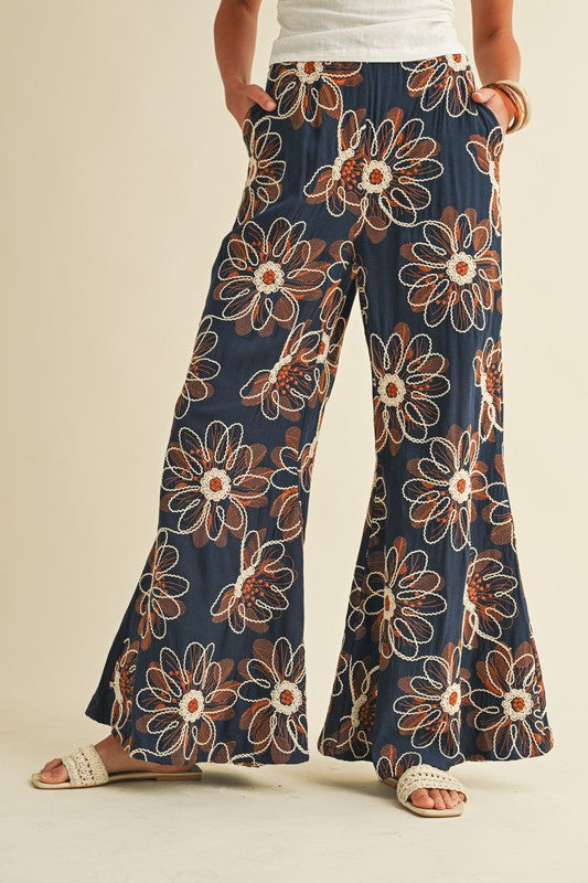 Floral patterned pants worn by a person on a beige background
