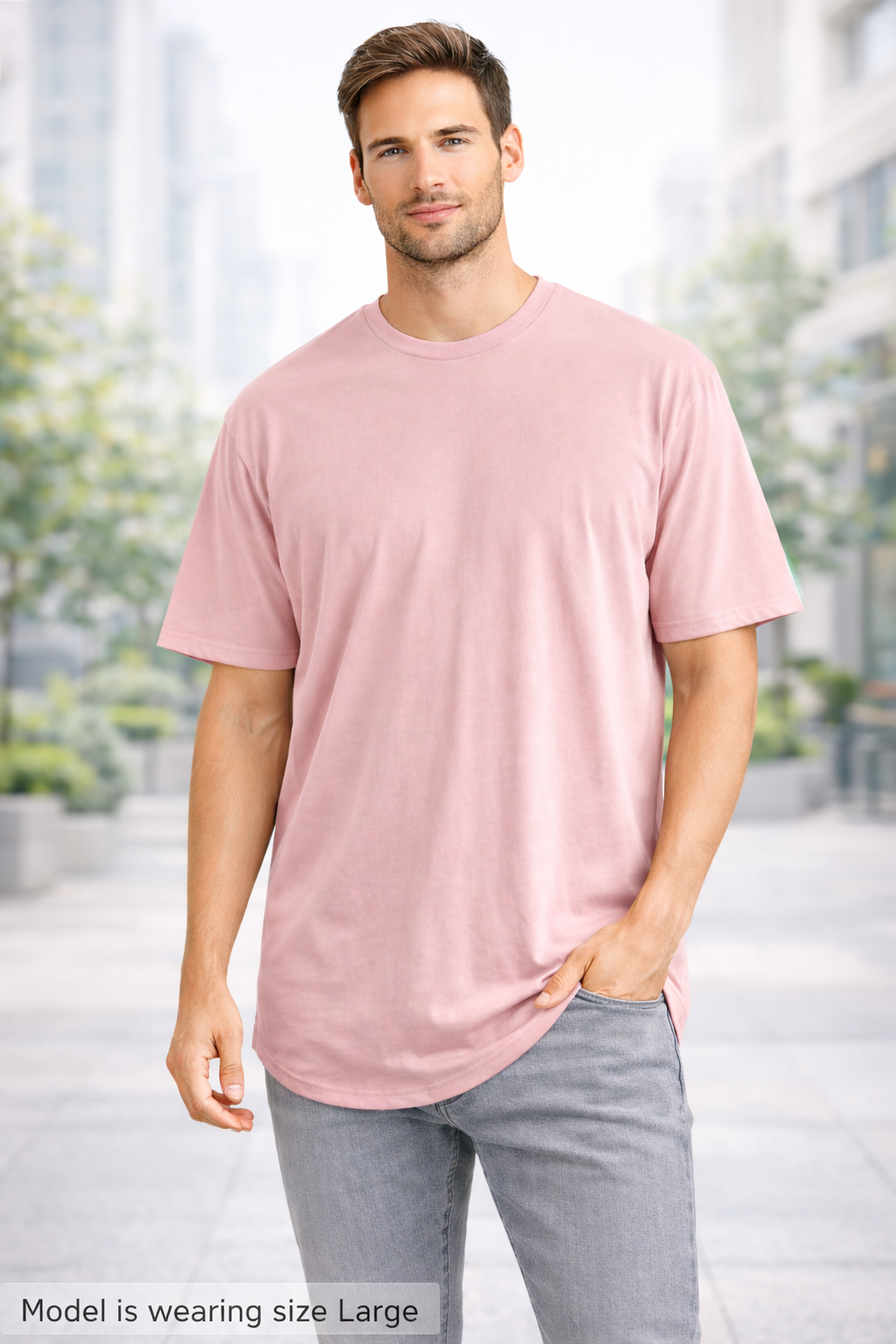 Man wearing a peach t-shirt and gray pants standing outdoors with blurred background
