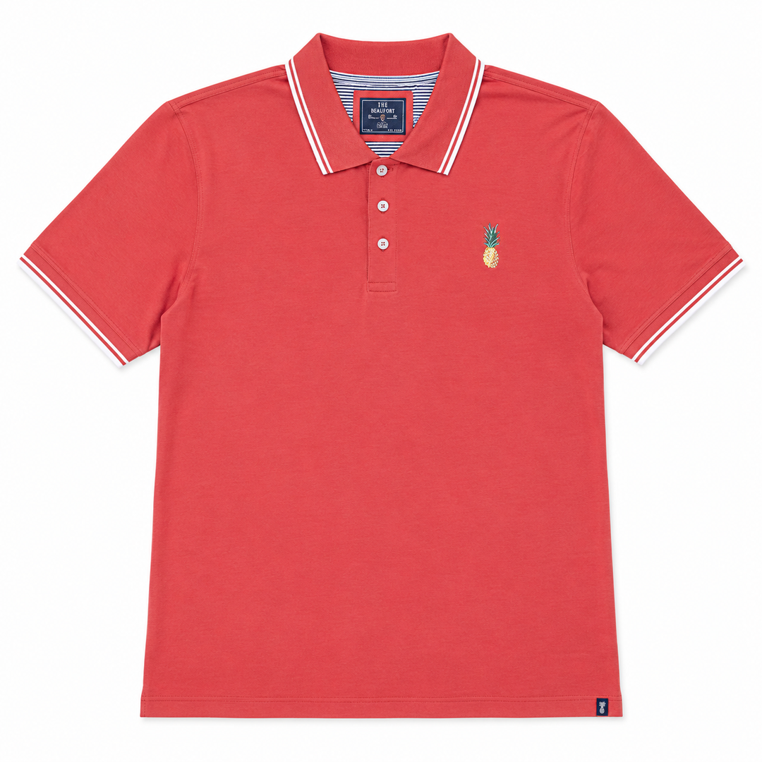 Pinkish polo shirt with a pineapple emblem on a white background