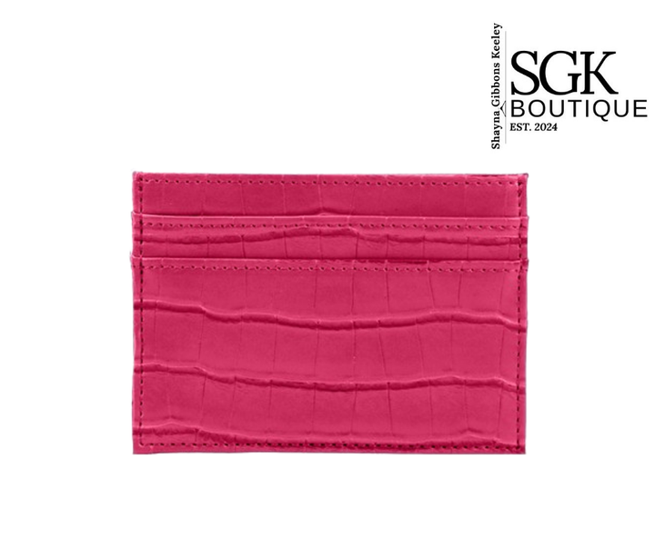 Pink crocodile-textured cardholder with SGK Boutique branding on a white background