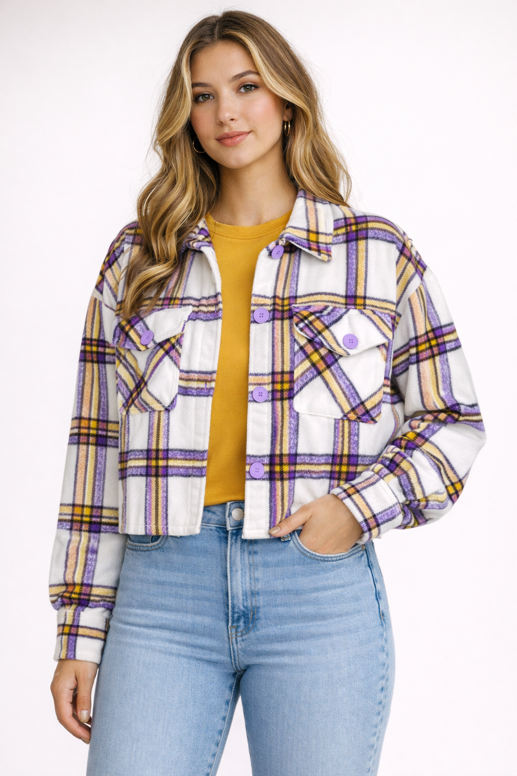 Woman wearing a plaid jacket, yellow top, and blue jeans on a white background