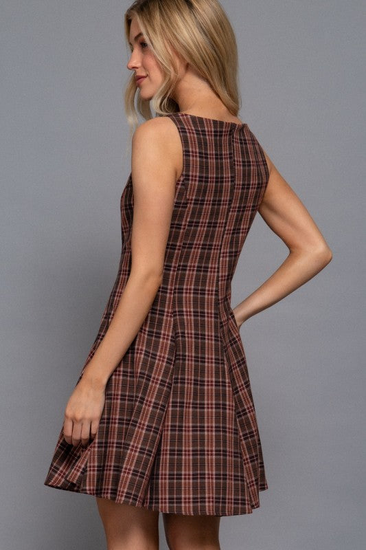 Woman wearing a plaid dress against a gray background