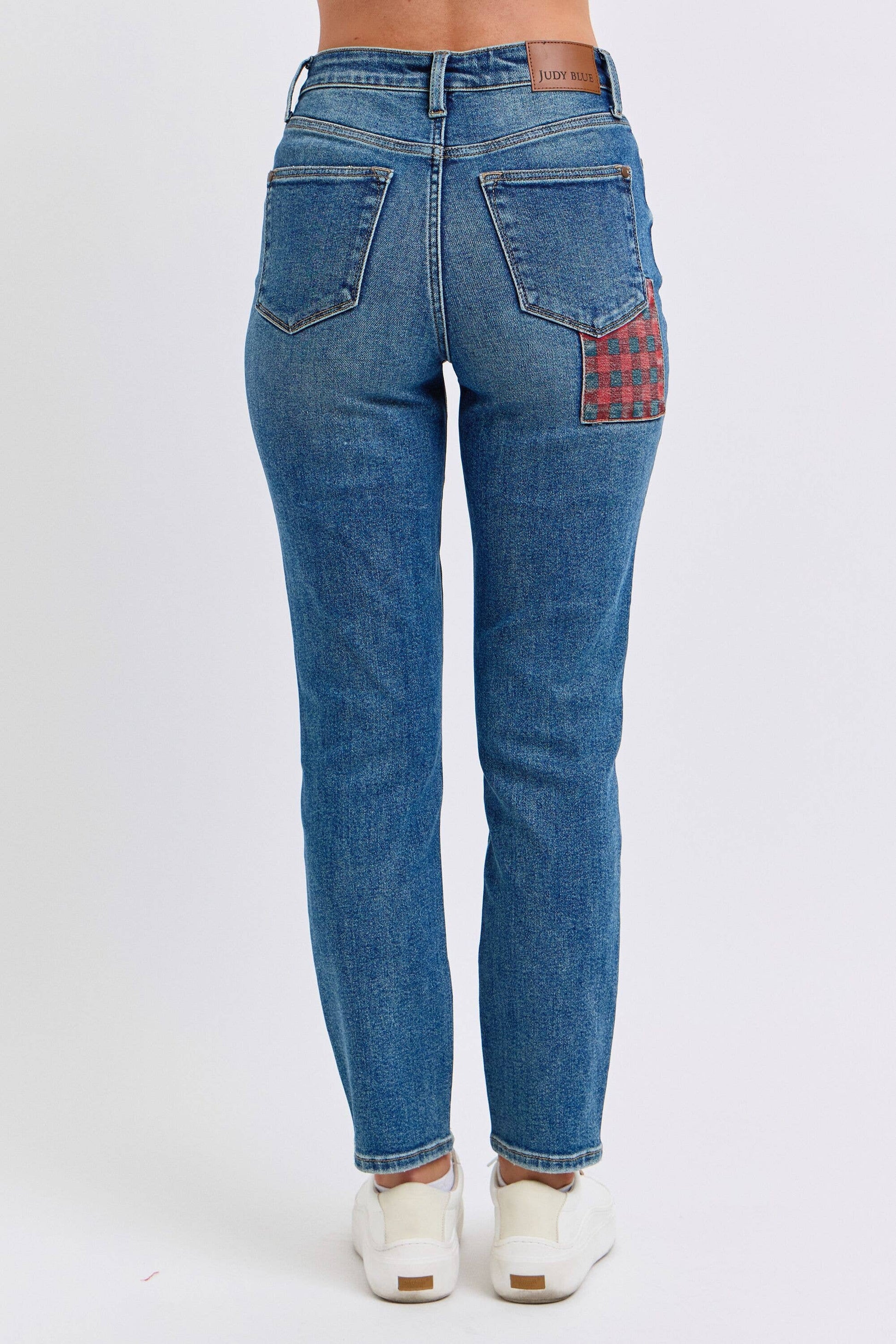 Blue jeans with plaid patch on a white background