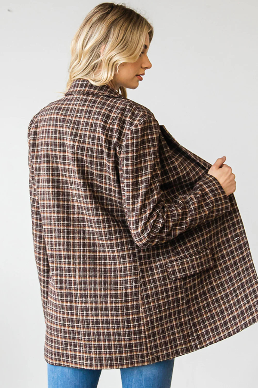 Person wearing a plaid coat on a plain background