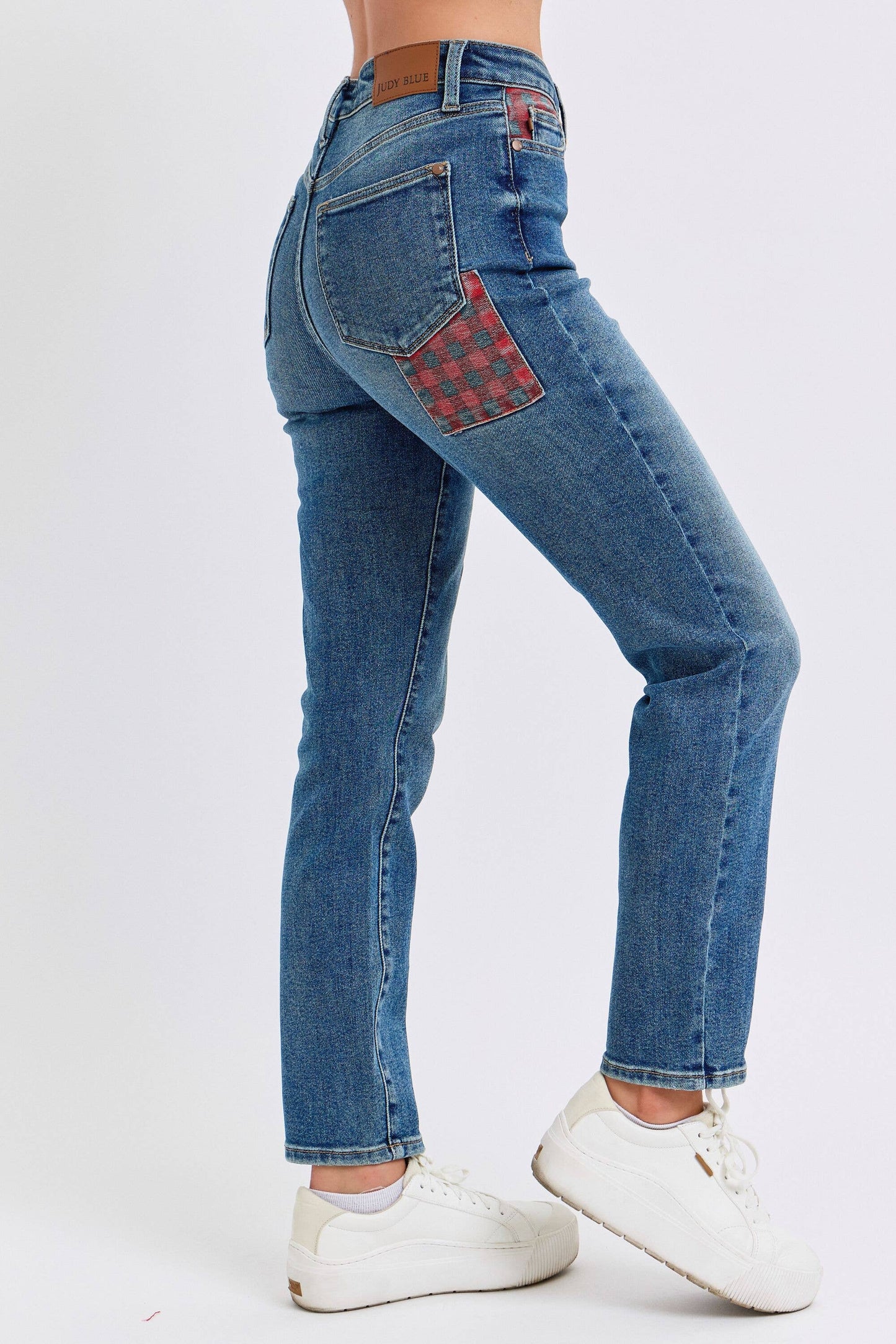 Blue jeans with a checkered patch on a white background