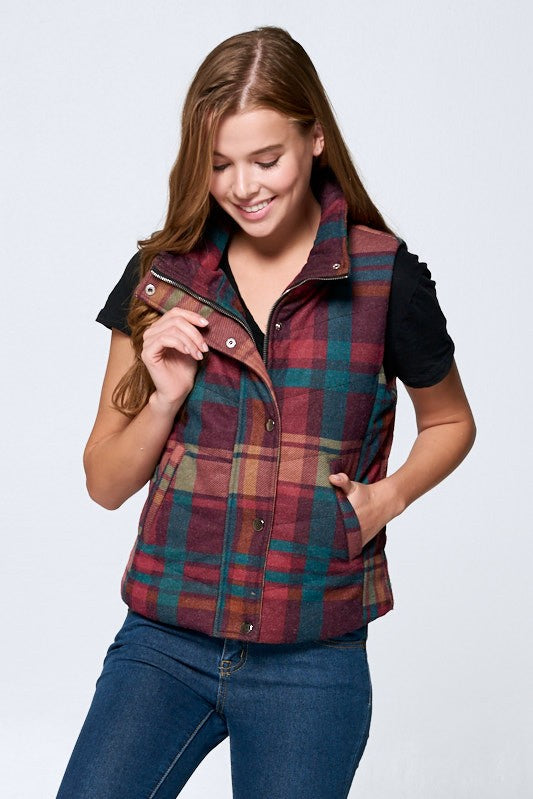Woman wearing a plaid vest over a black shirt on a white background