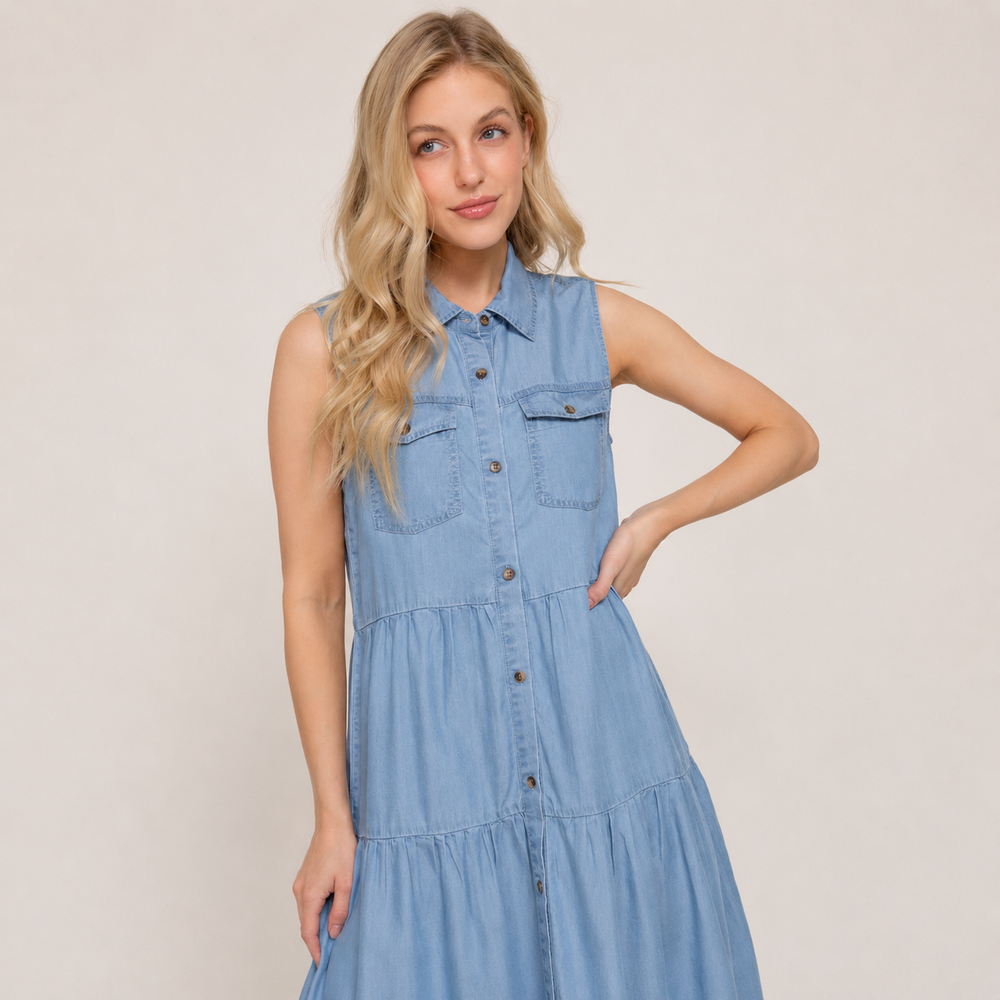 Woman wearing a light blue denim dress against a plain background