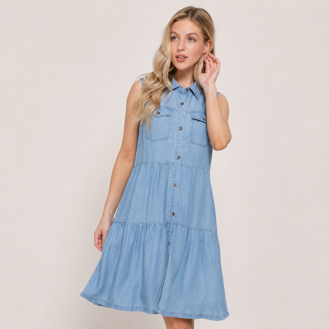 Woman wearing a light blue denim dress against a plain background