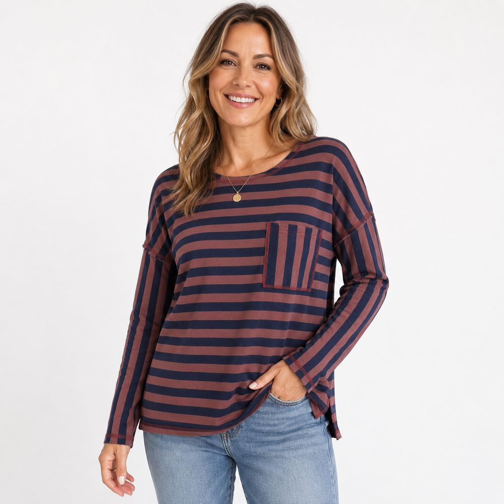 A woman modeling a long-sleeve striped top with a chest pocket, paired with blue jeans, against a plain white studio background.