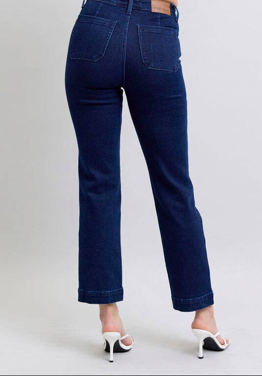 Blue jeans worn by a person on a plain background