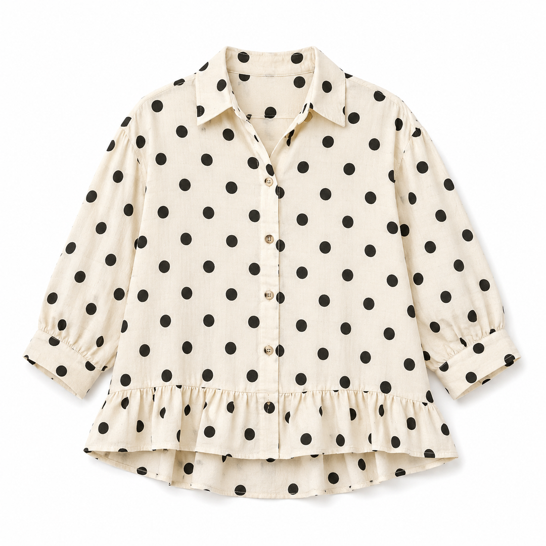 White blouse with black polka dot pattern on a white background