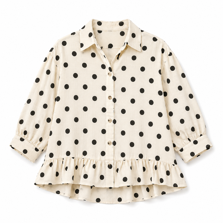 White blouse with black polka dot pattern on a white background