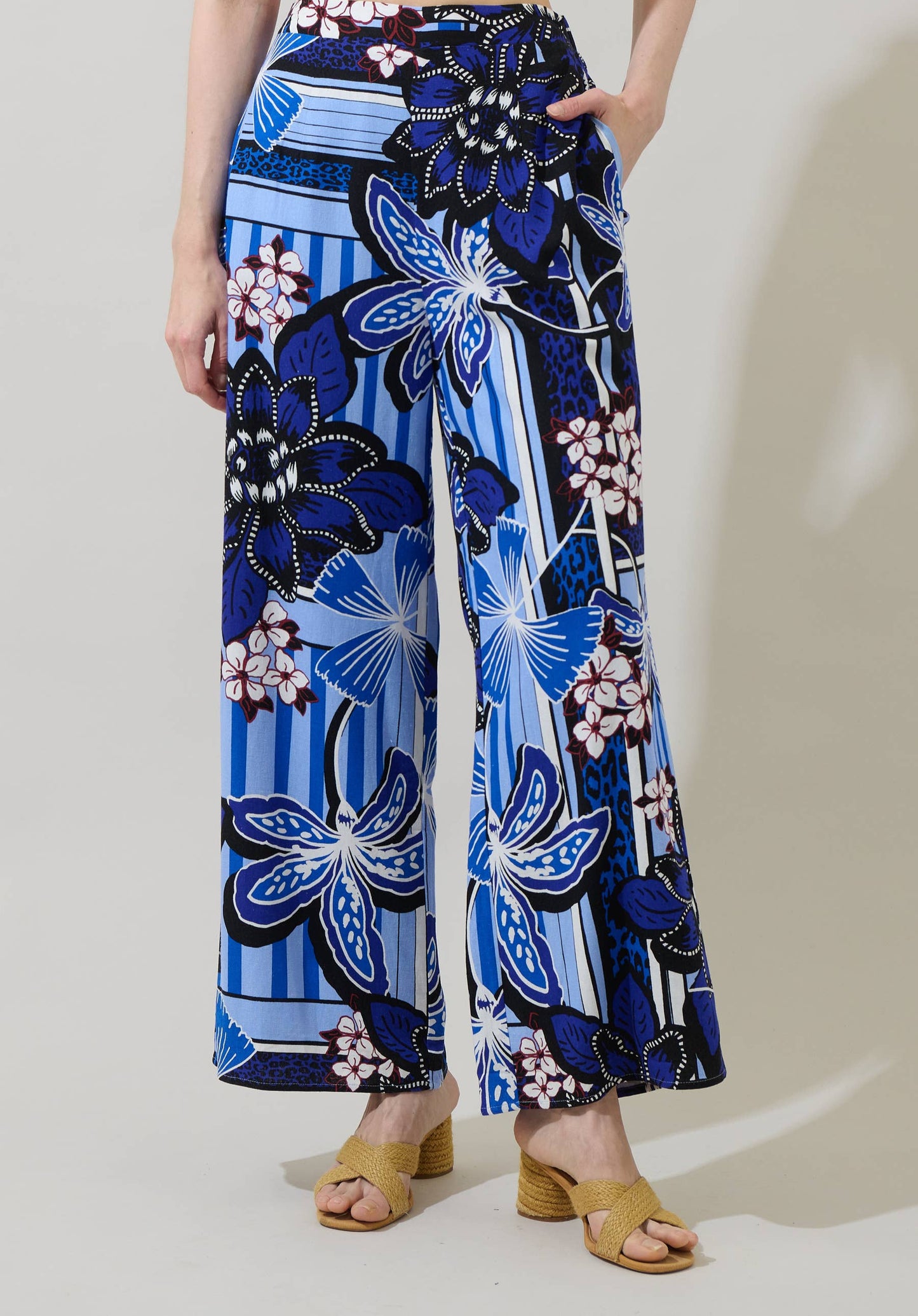 Person wearing blue floral patterned pants on a plain background