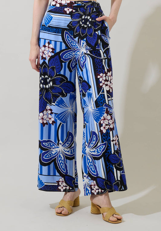 Person wearing blue floral patterned pants on a plain background